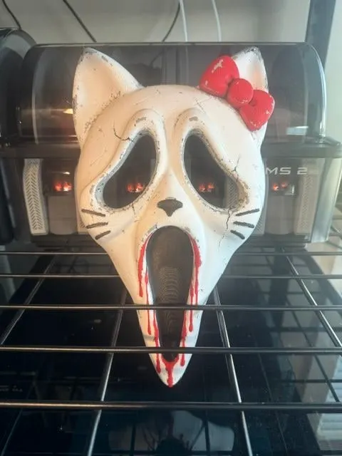 Horror mash-up mask combining a cartoon cat and a ghost face, distressed finish