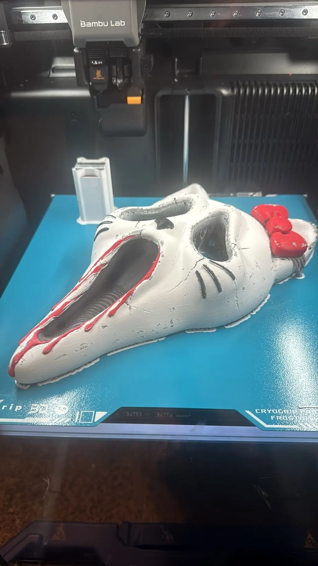 The same horror mash-up mask still sitting on the printer's build plate