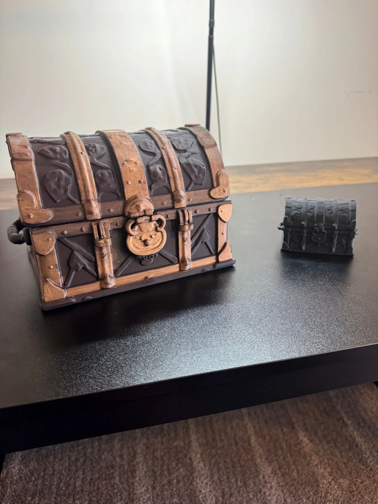 Large painted bronze treasure chest beside a smaller gray one