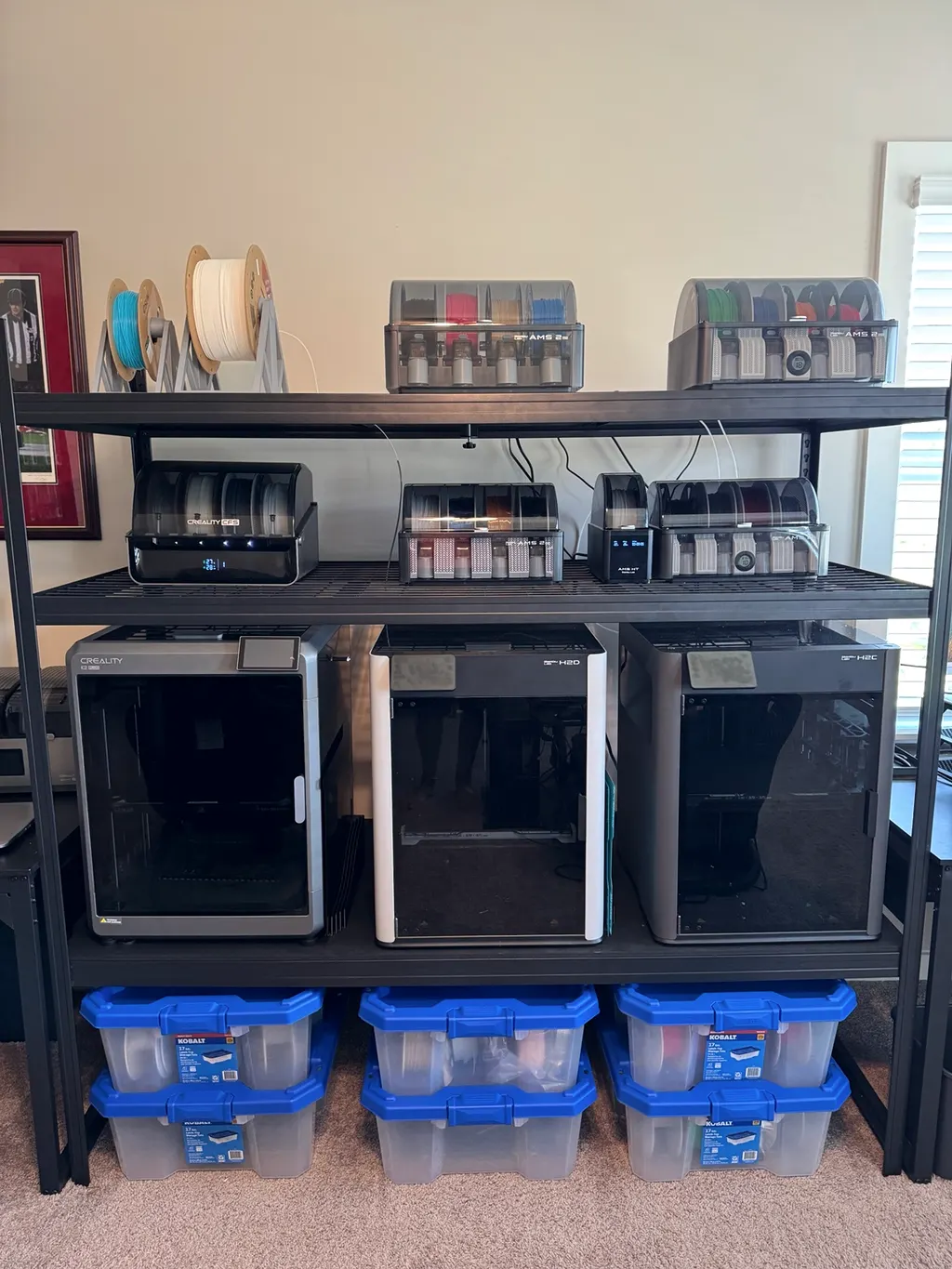 Three printers on one rack, each with its multi-material filament system above it